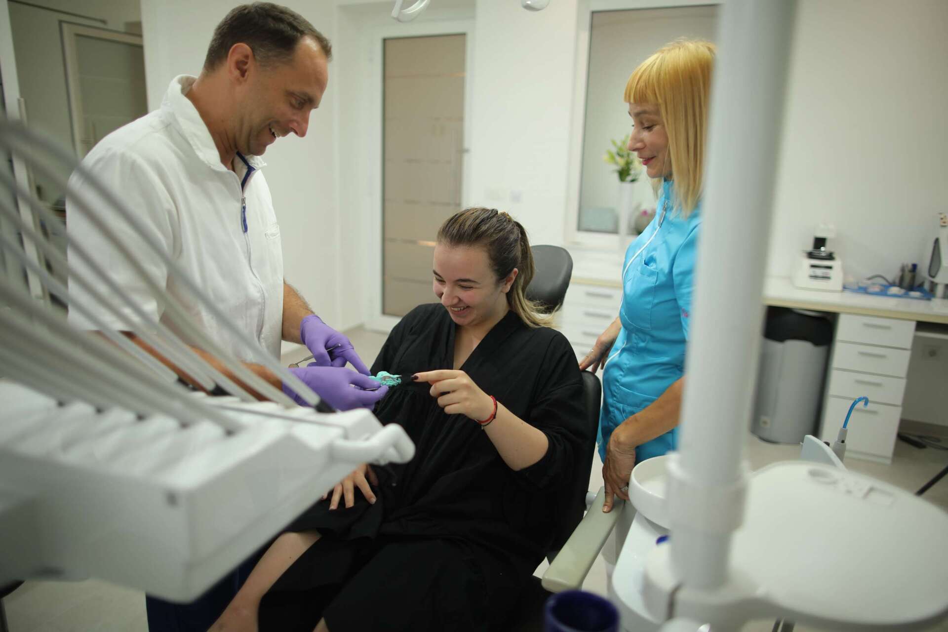 Dentalne usluge - zubar i pacijentica su nasmijani